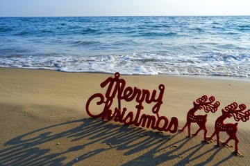 Happy new year concept, Merry Christmas put on sand beach in sunrise. 