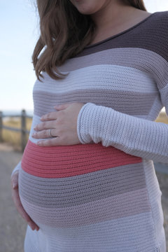 Pregnant woman holding her stomach.