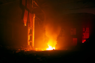 Fire in factory building at night. Burned by fire industrial warehouse