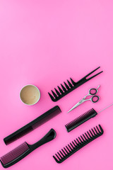 Fototapeta premium female hairdresser desk with accessories and combs on pink background top view mock up