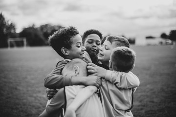 Junior football team hugging each other