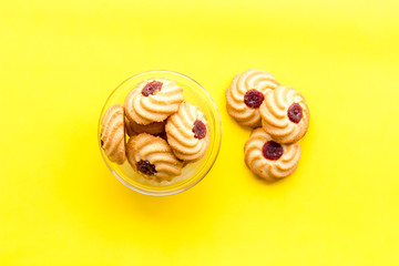 Homemade cookies. Kurabe in glass bowl on yellow background top view copy space