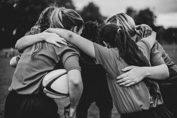 Young female rugby players huddling - obrazy, fototapety, plakaty
