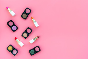 Professional cosmetics set with palette of eyeshadows on pink background top view copyspace