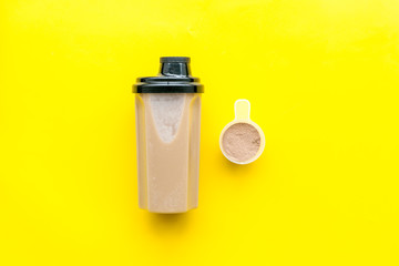 protein cocktail with powder for sport nutrition set l on yellow background top view mock-up