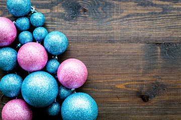 Toys for New Year tree 2019 background. Blue and pink balls and stars on dark wooden background top view copy space border