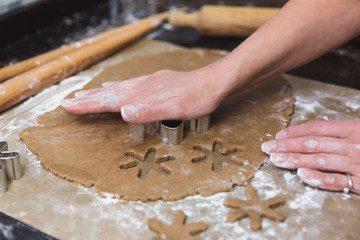 Woman makes christmas gingerbread cookies on black and red background