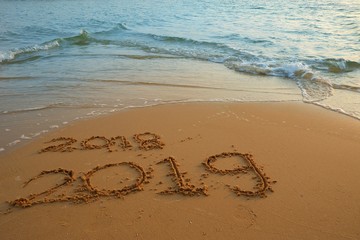 Happy new year concept, 2019 put on sand beach in sunrise.
