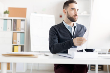 Fototapeta premium Portrait of handsome bearded businessman working at desk in modern office, copy space