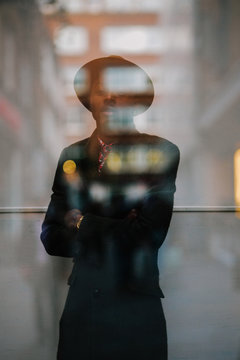 Double exposure portrait of a cool tattooed black millenial man with reflection through glass