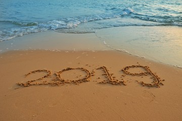 Happy new year concept, 2019 put on sand beach in sunrise.