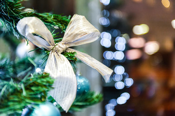 Christmas ball ribbon, baw on the tree in the background with other decorations and garlands. copy space.