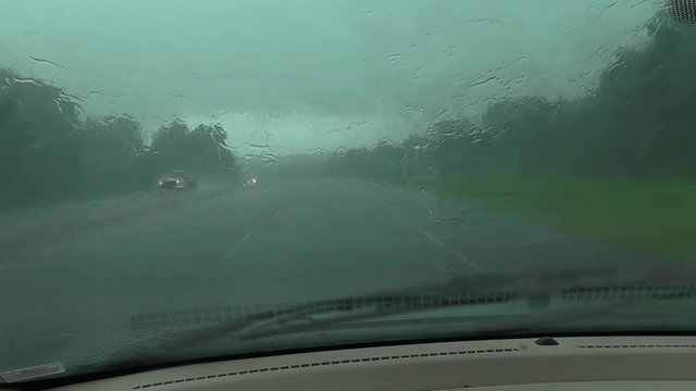 Car Driving Through a Rain Storm with Windshild Wipers on Full