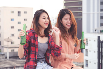 Young asian woman sitting and smiling at rooftop outdoor in urban city background, happy lifestyle