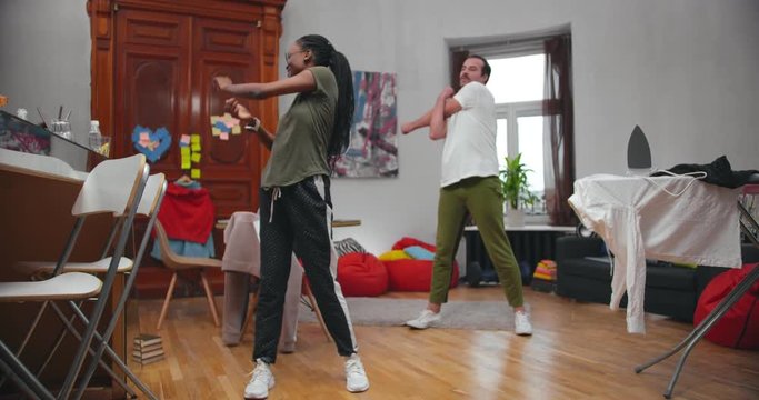 Active young couple engaged gymnastics, doing stretching for muscles hands