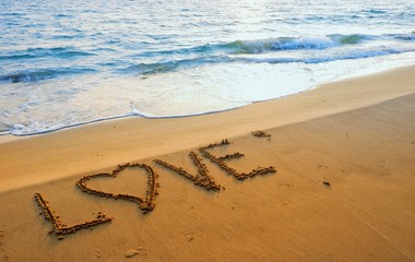 Marry concept, love heart shape handwriting on sand beach in sunrise.