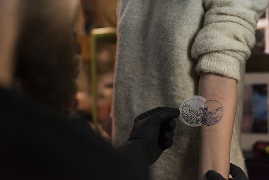 Tattooist putting sketch on arm