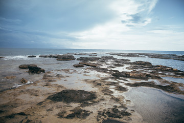 Fototapeta na wymiar Sea and sand under a cloudy sky