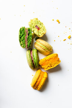 three colors macarons in a cut, close up, fillings on a white background