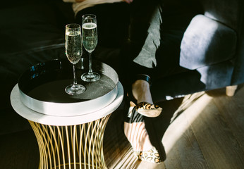 Glasses of champagne or sparkling wine on a table in a shaft of sunlight.
