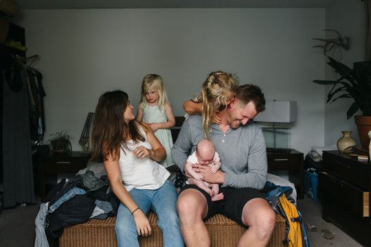 Young Family With Three Kids, Crying Baby And Laughing Parents