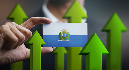 Nation Growth Concept, Green Up Arrows - Businessman Holding Card of San Marino Flag
