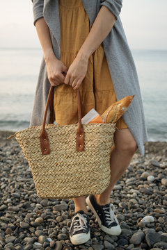 Unidentified person holding shopping bag with baget