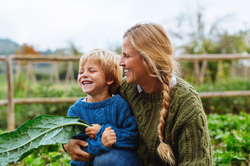 Mother and her son having fun on their orchard. 