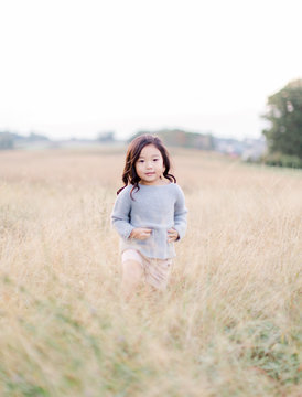 Little girl standing in a soy bean field