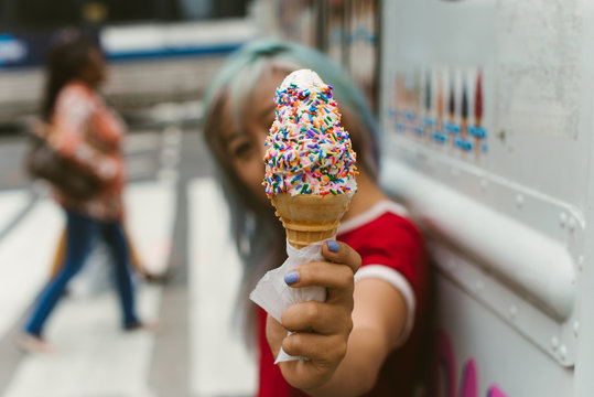 Ice cream cone with rainbow sprinkles in the city