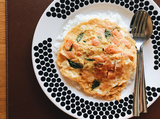 Salmon omelette with rice in a large dish on a brown plate