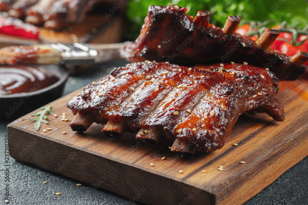 Wall mural closeup of pork ribs grilled with bbq sauce and caramelized in honey. tasty snack to beer on a woode