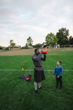 Man and boy enjoying speed parachute training together in field 