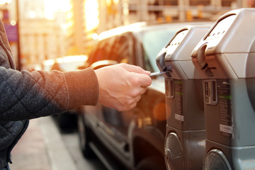 man is paying his parking using credit card at  parking pay station terminal