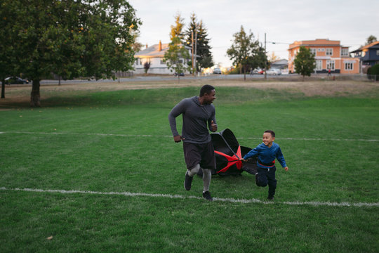 Man and boy enjoying speed parachute training together in field 