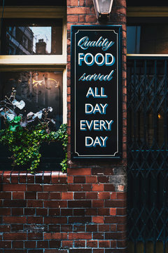 Sign on a wall says "" Quality food served all day every day ""