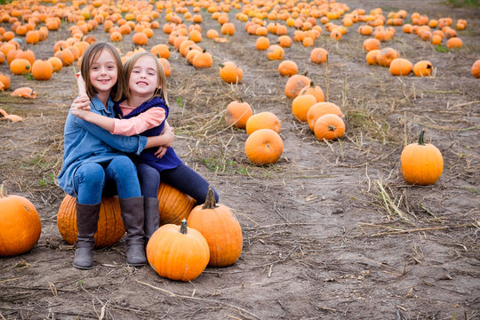 Two sisters in a pumpkin patch