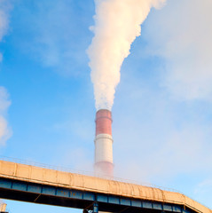 Smoke comes out of the pipe at the heat and power station. Panorama. Morning. Winter