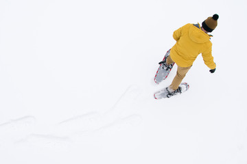 man in snowshoes goes on the snow, a long hike