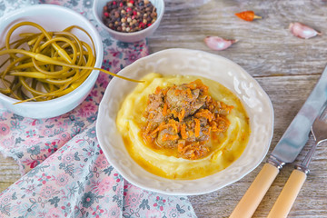 Fried chicken liver with carrots and onion and garnish of mashed potatoes,served with parsley and marinated garlic arrows