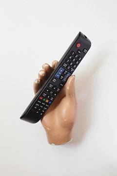 Fake mannequin hand hold television remote control
