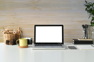 Workspace mockup laptop computer, coffee mug, books and office supplies on desk work.