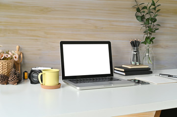 Workspace mockup laptop computer, coffee mug, books and office supplies on desk work.