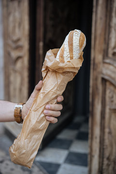 Unidentified person holding french baget bread