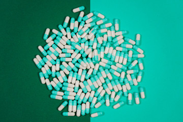 Pharmaceutical medicine pills, capsules on colored background.