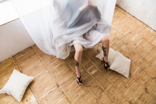 legs of young woman with tattoo in drapes