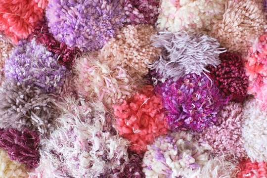 Colourful homemade pom pom rug