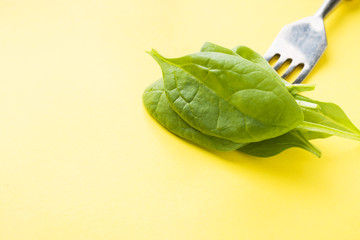 Fresh spinach leaves strung on a fork. Healthy eating concept