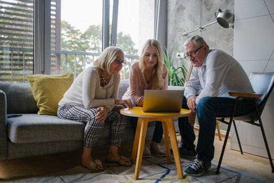 Grandparents and Granddaughter Looking at Laptop