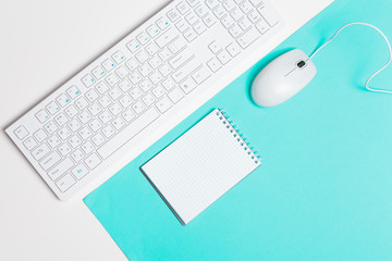 Computer keyboard and mouse on color block background, office interior